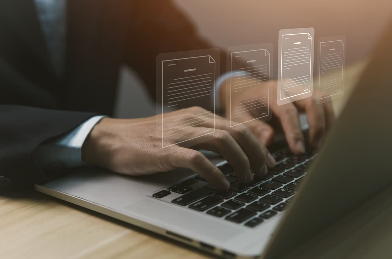 Affärsman i kostym skriver på en laptop med digitala dokumentikoner svävande ovanför, vilket symboliserar online notarisering och digital hantering av juridiska dokument. Bilden representerar Notarius Publicus roll i den digitala eran och hur tjänster som Apostille online förenklar internationell dokumentlegalisering via Apostille24.se