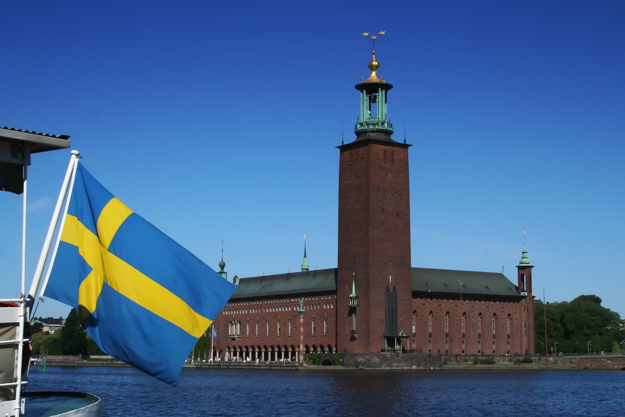 Svenska flaggan framför Stockholms stadshus – symbol för officiella notarietjänster och apostille i Sverige.